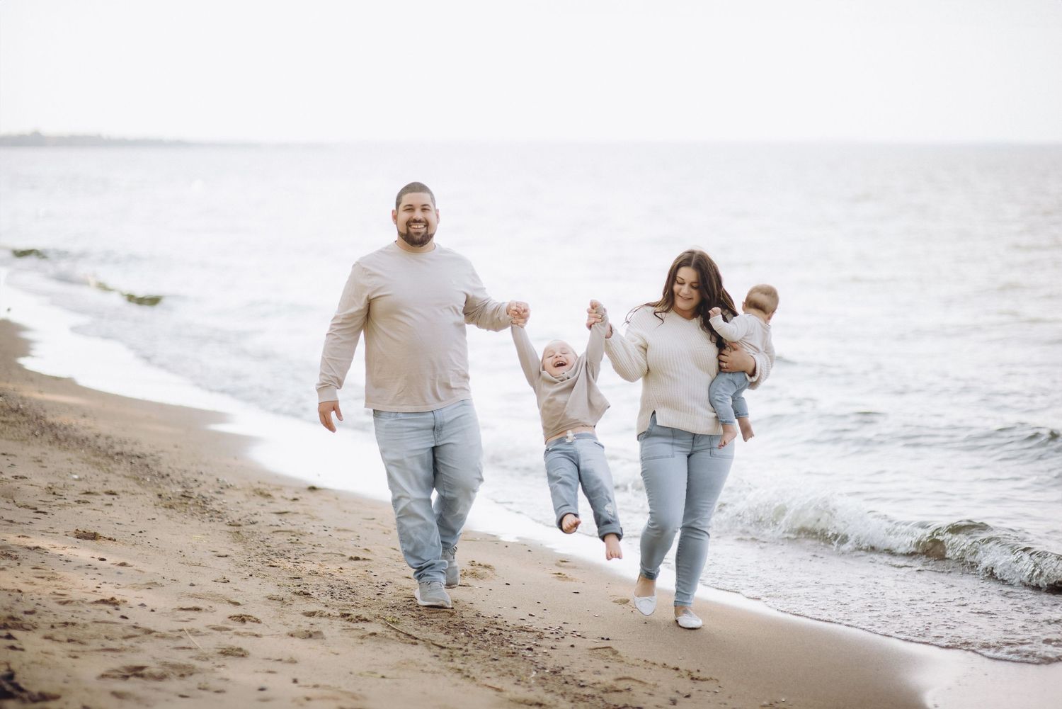 Family of four play happily on the beach