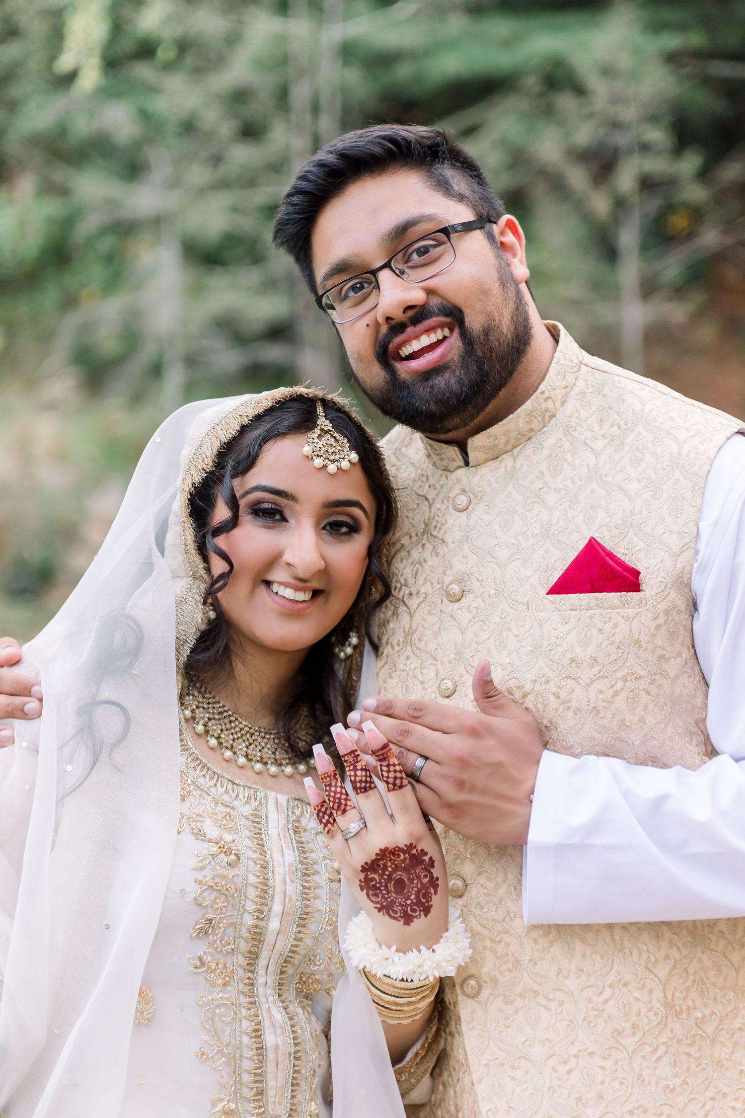 Traditional South Asian wedding couple in ornate cream and white attire.