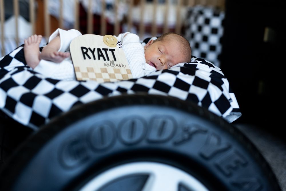 Black and white checkered racing-themed newborn photography setup.