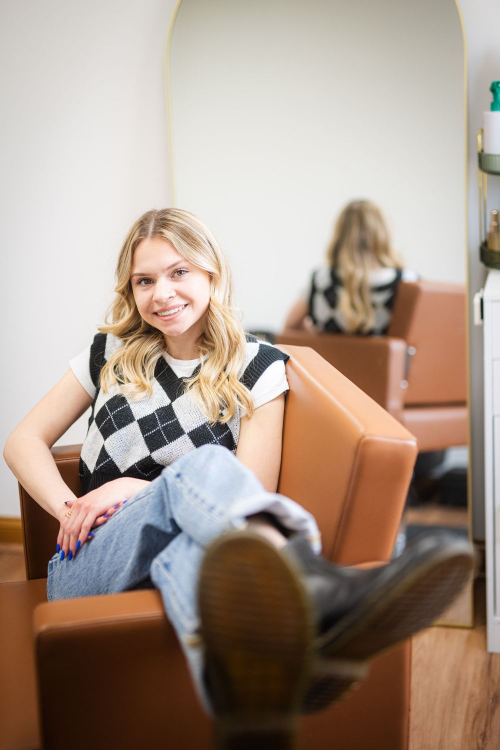 Casual portrait session in a room with tan leather chairs and natural lighting.