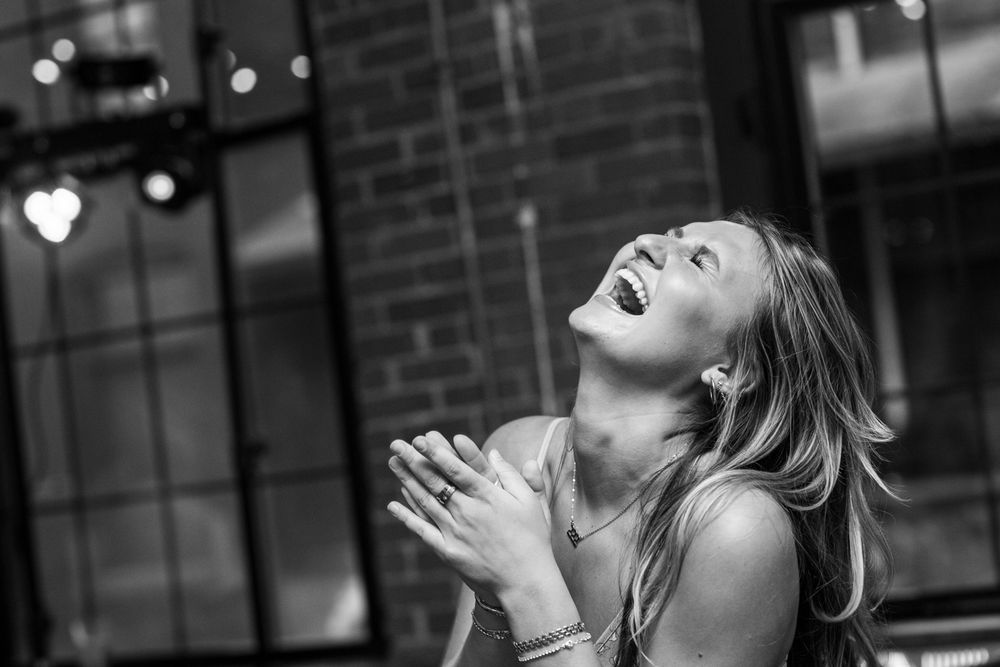 Black and white photo series showing expressions of joy and laughter in dramatic lighting.