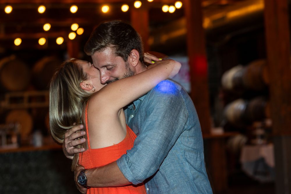 Two people share an intimate dance moment under warm lighting at an indoor venue.