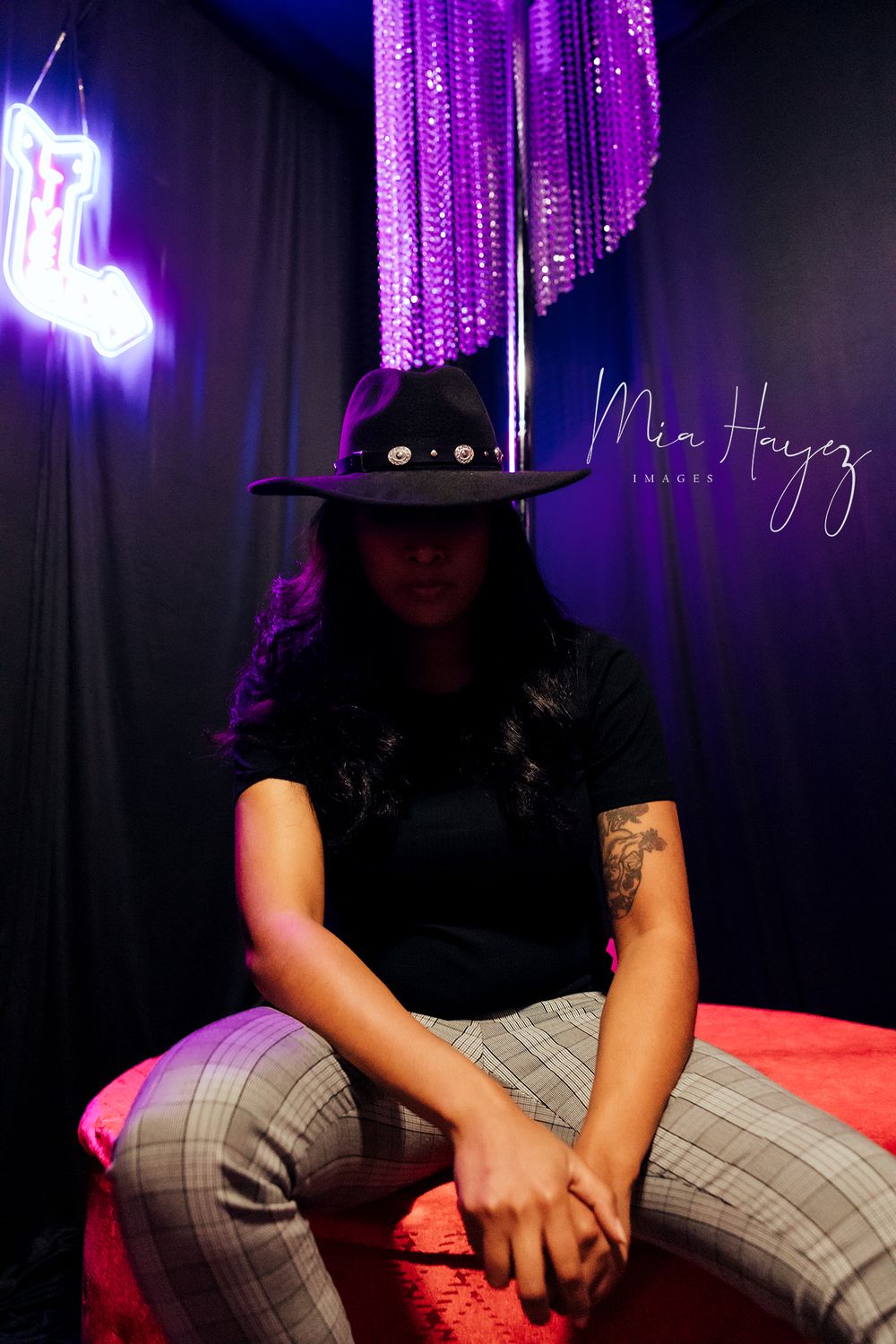 Moody portrait series with purple lighting showing casual poses in plaid pants.