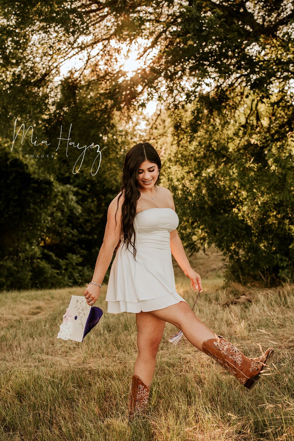 Playful outdoor photo sequence in a field at golden hour wearing a white dress and cowboy boots.