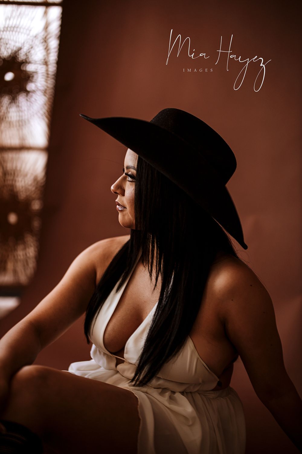 Stylish portrait series featuring a wide-brimmed hat and white top in warm sepia tones.