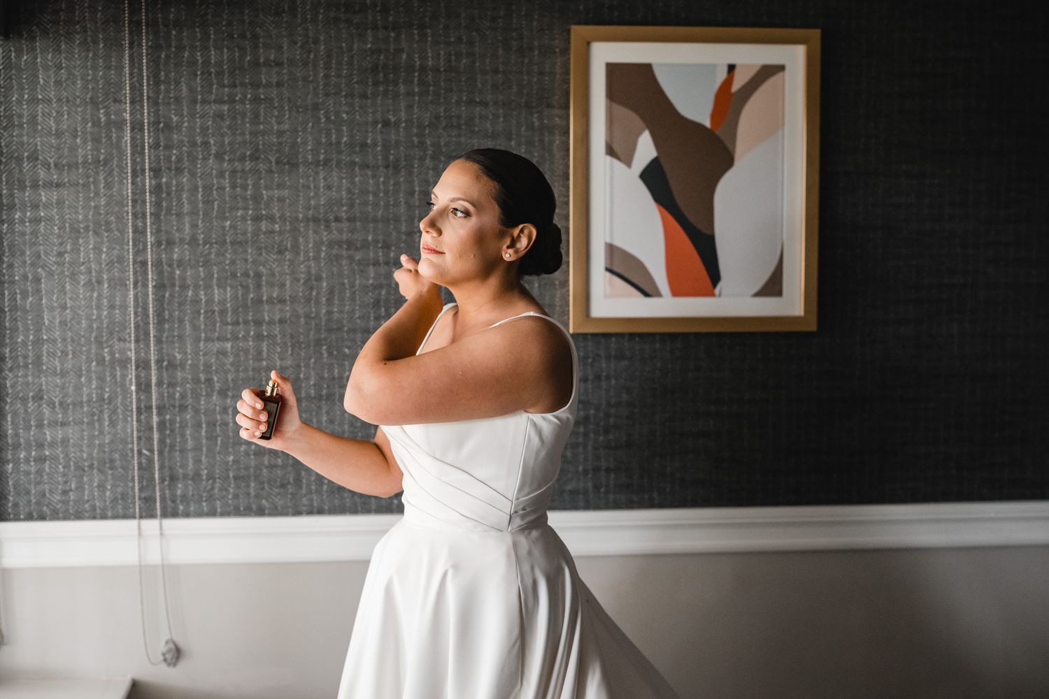 Final wedding preparation touches in a room with modern abstract wall art.
