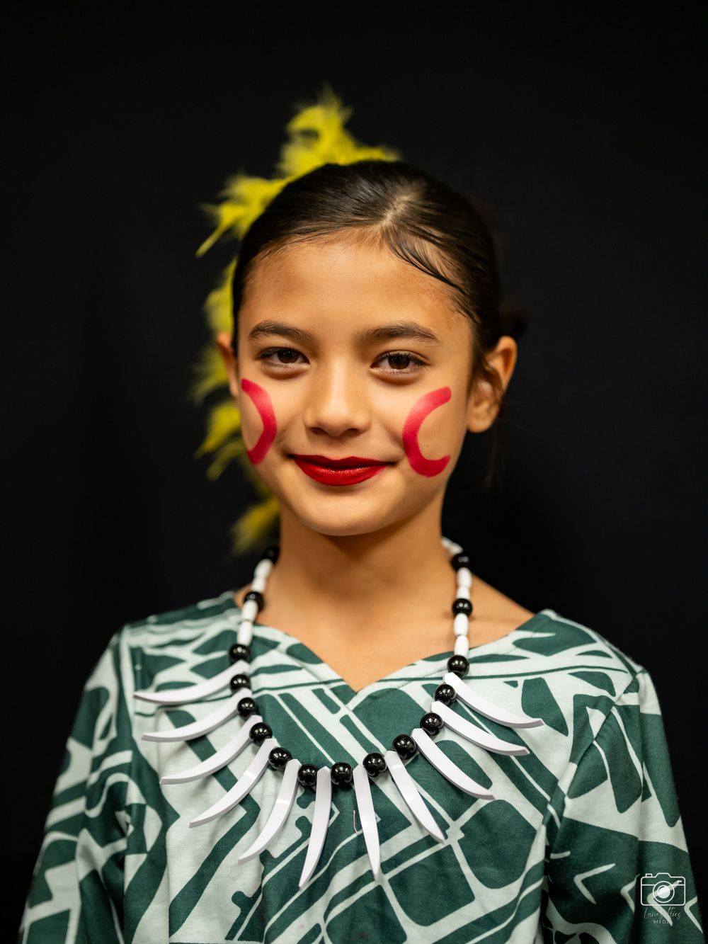 A series of four close-up photos showing traditional face paint and a floral hair accessory against a dark background.