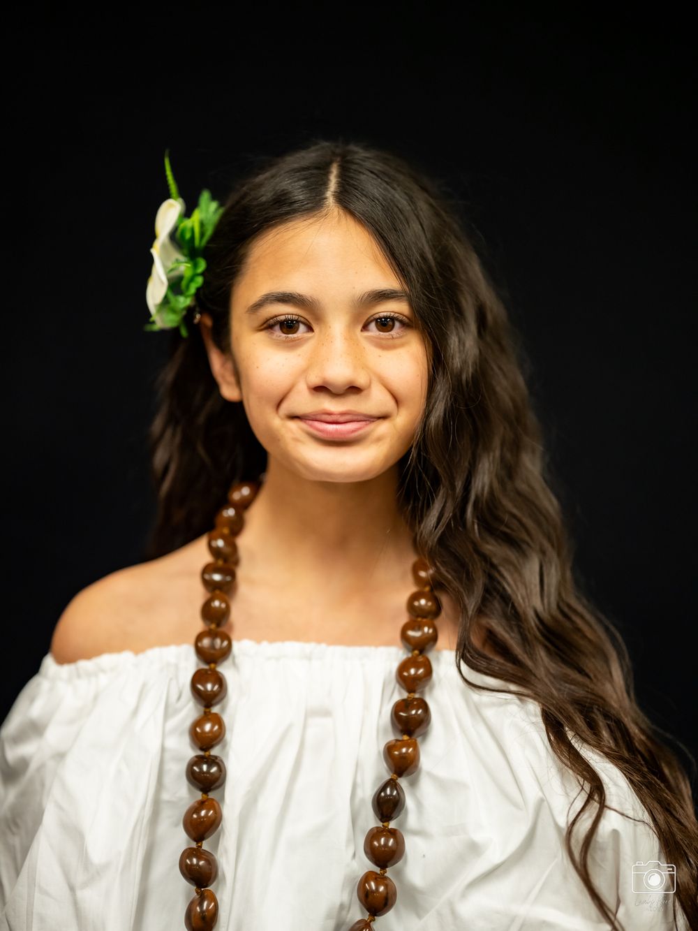 Portrait sequence showing progressive smiles while wearing a white top and wooden bead necklace.