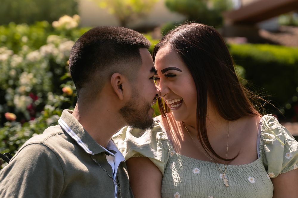 Romantic couple embracing in a garden setting with blooming flowers.