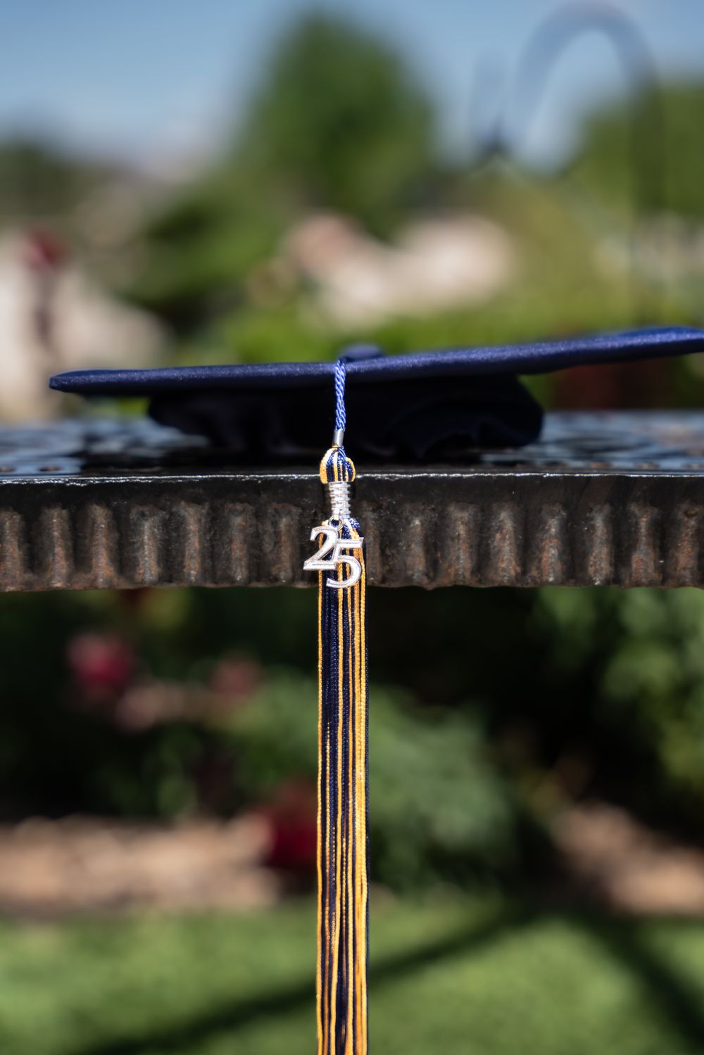 Close-up of graduation tassel with gold detailing against blurred background.
