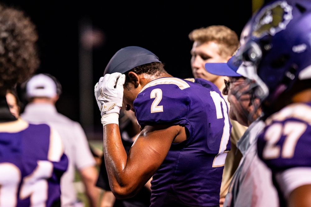 Football players in purple jerseys celebrate during a game.