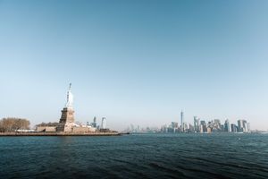 Panoramic view of New York Harbor showing Statue of Liberty and city skyline.