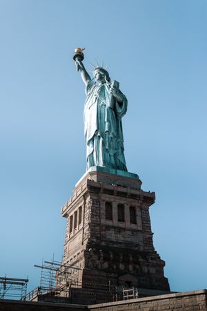 Progressive close-up sequence of the Statue of Liberty's crown and torch against a blue sky.