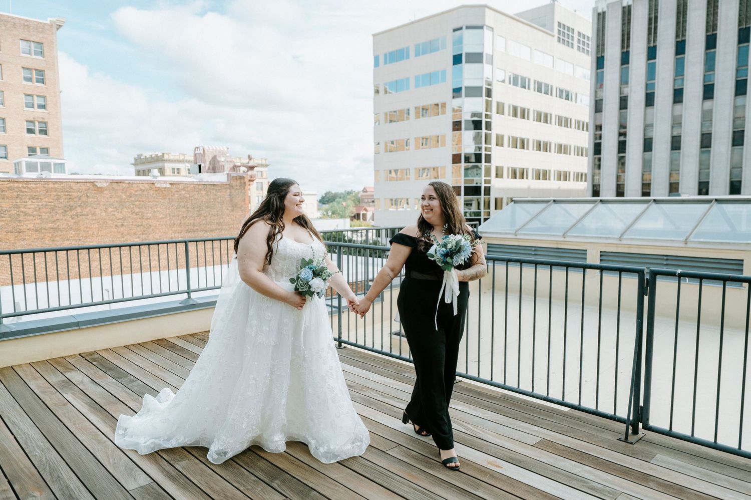 A panoramic sequence of wedding photos showing a couple's first look moment on a rooftop deck with city buildings behind them.