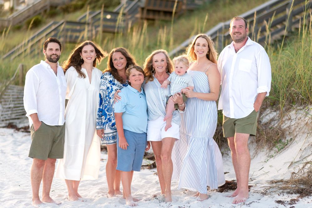 30A Photographer at group photo session on a beach with dunes and sea grass in the background.