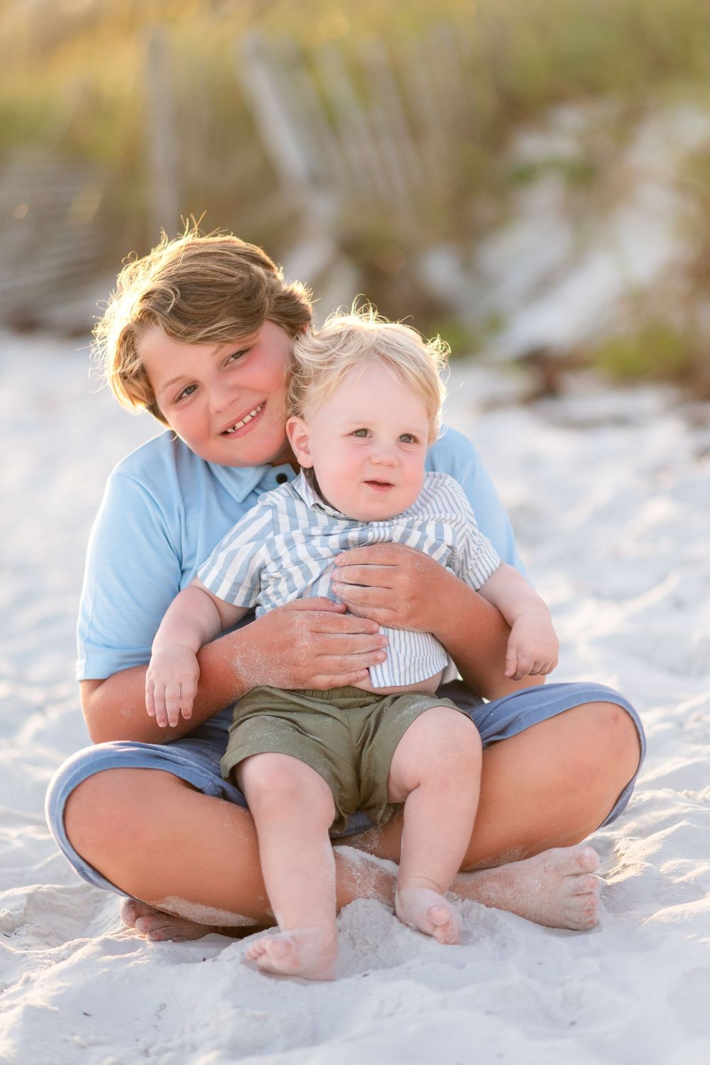 30A Photographer captures A sweet candid beach photo sequence showing playful moments between parent and child sitting in white sand.