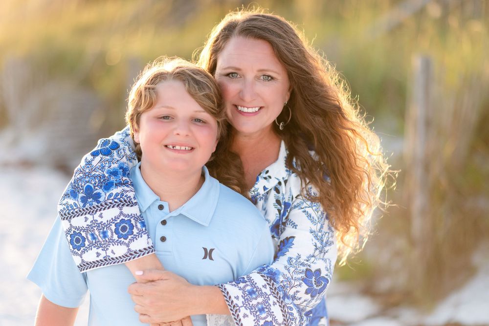 30A Photographer captures two people in matching blue and white patterned outfits embrace and smile during a sunny outdoor photoshoot.