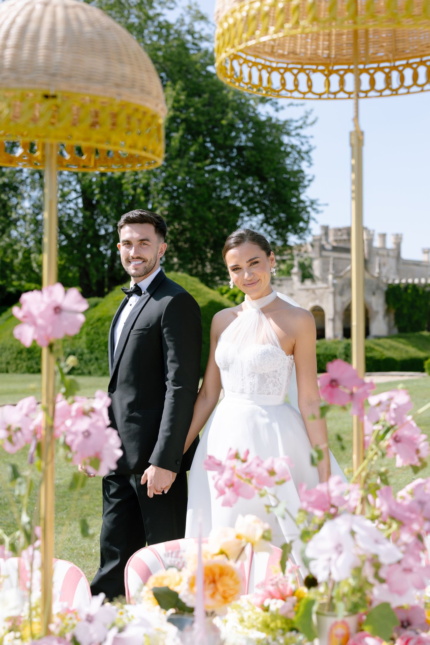 Garden wedding scene with decorative yellow umbrellas and pink floral arrangements.