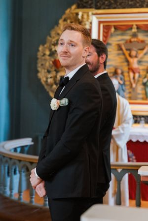 Brudgommen er rørt da han ser bruden komme inn dørene.
