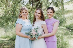 Bilde av bruden og forlovere. Alle holder på buketten for å skape en enhet i bildet.
