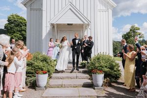 Brudepar på kirketrappen. Det klappes, jubles og blåses såpebobler.