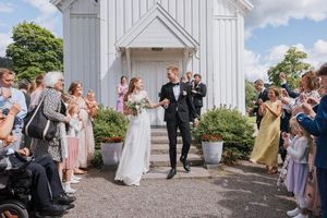 Brudepar på kirketrappen. Det klappes, jubles og blåses såpebobler.