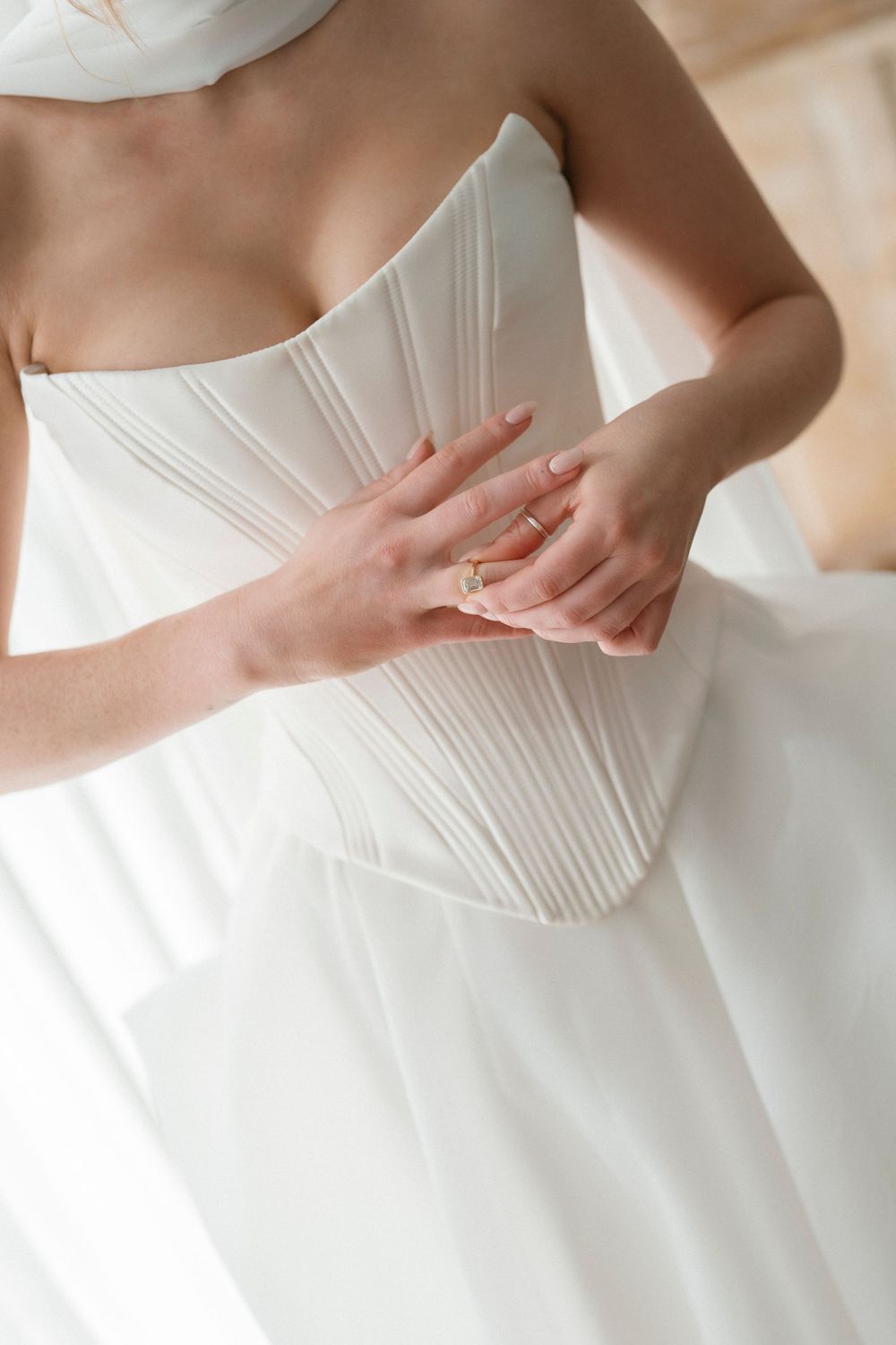 Close-up details of a white wedding dress bodice with pleated architectural details shown from different angles.