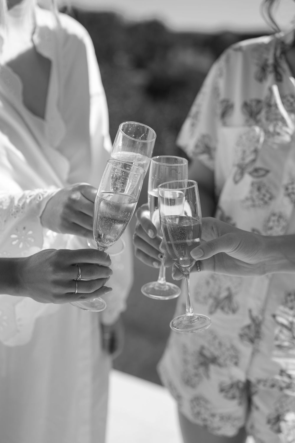 Black and white photo series showing hands holding wine glasses in a celebratory toast sequence.