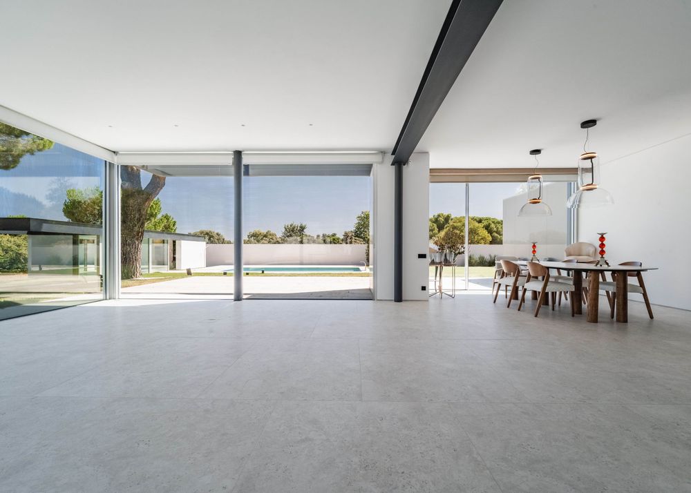 lujoso salón con ventanas grandes y vistas a la piscina