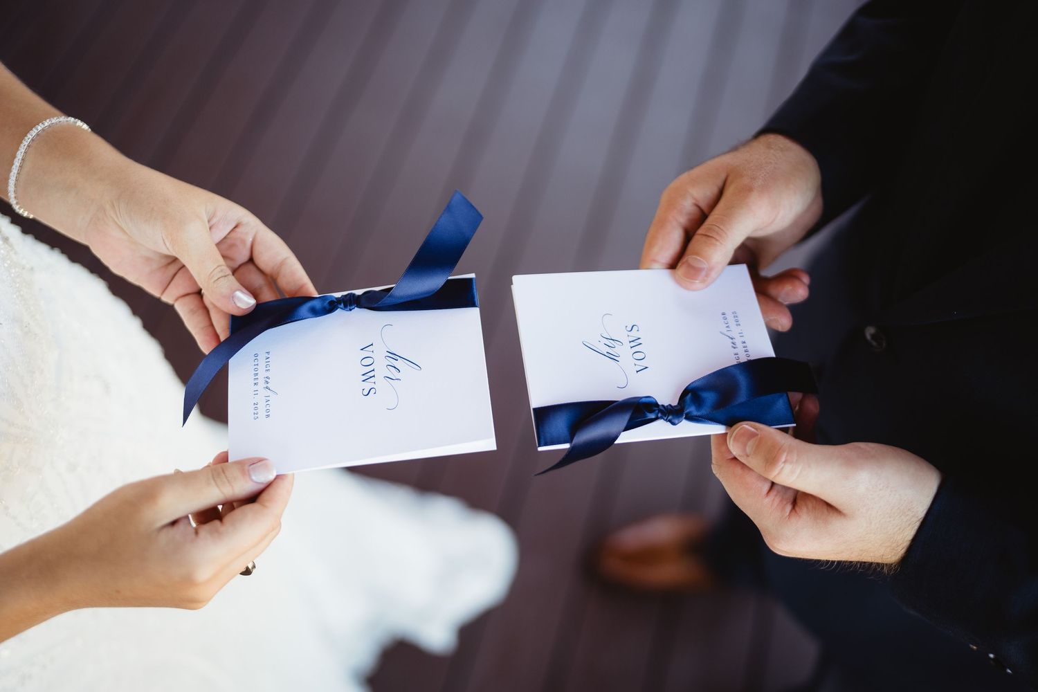 Close-up view of hands writing notes with blue pen on white paper during a meeting or study session.