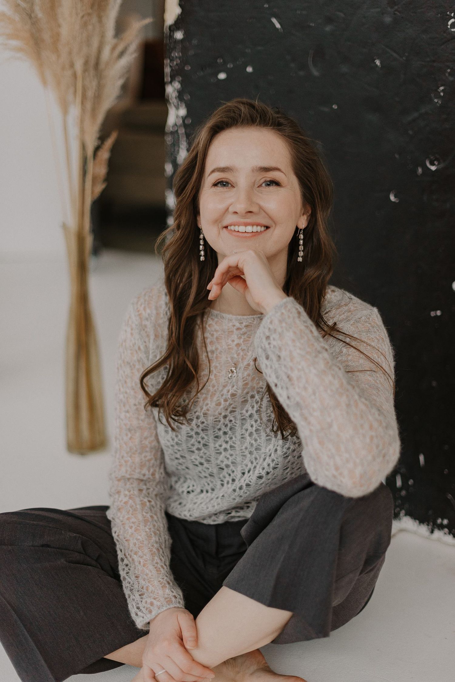 Cozy winter fashion shot featuring a cream knit sweater and dark pants.