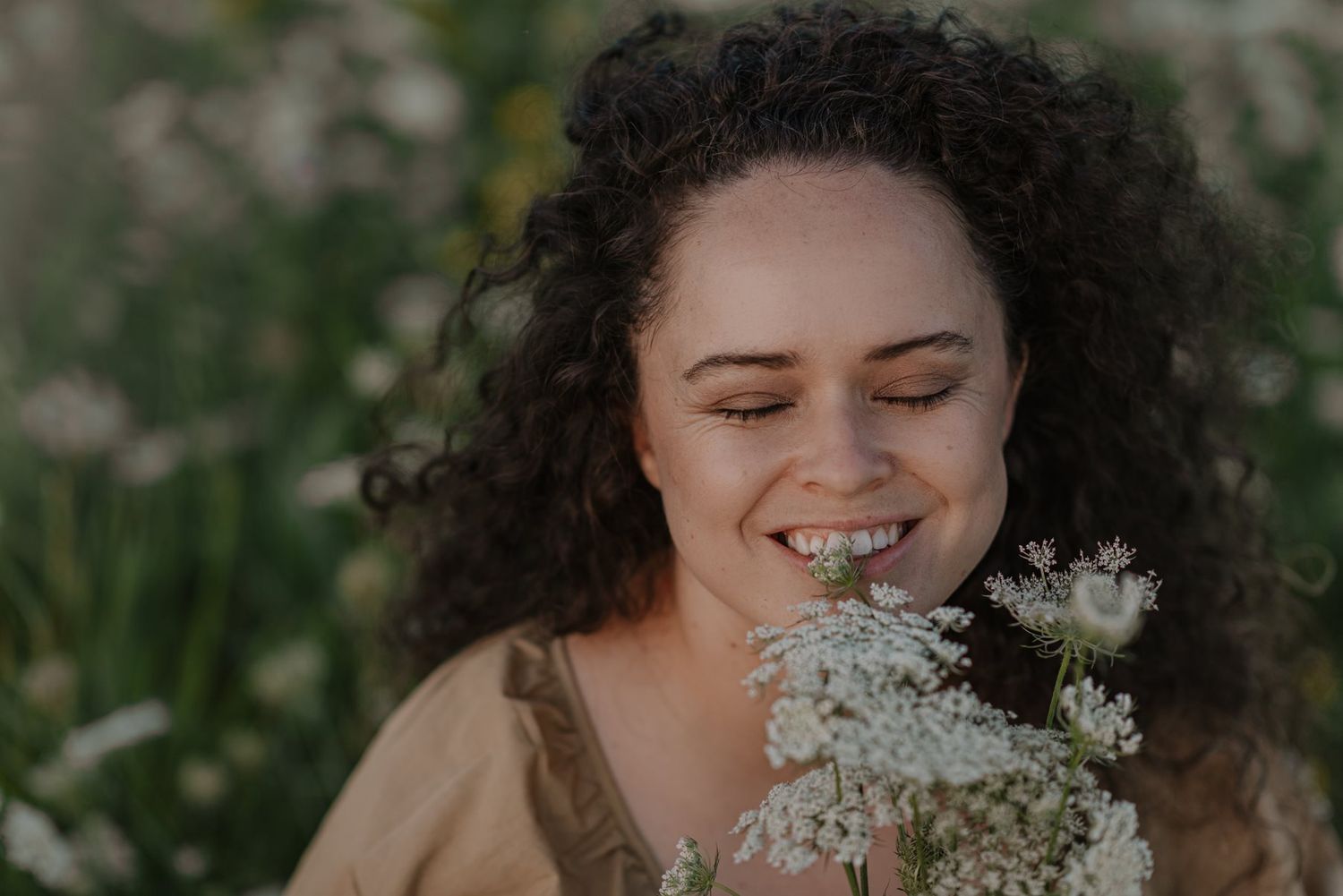Close-up portrait with white flowers creating a dreamy, natural atmosphere.