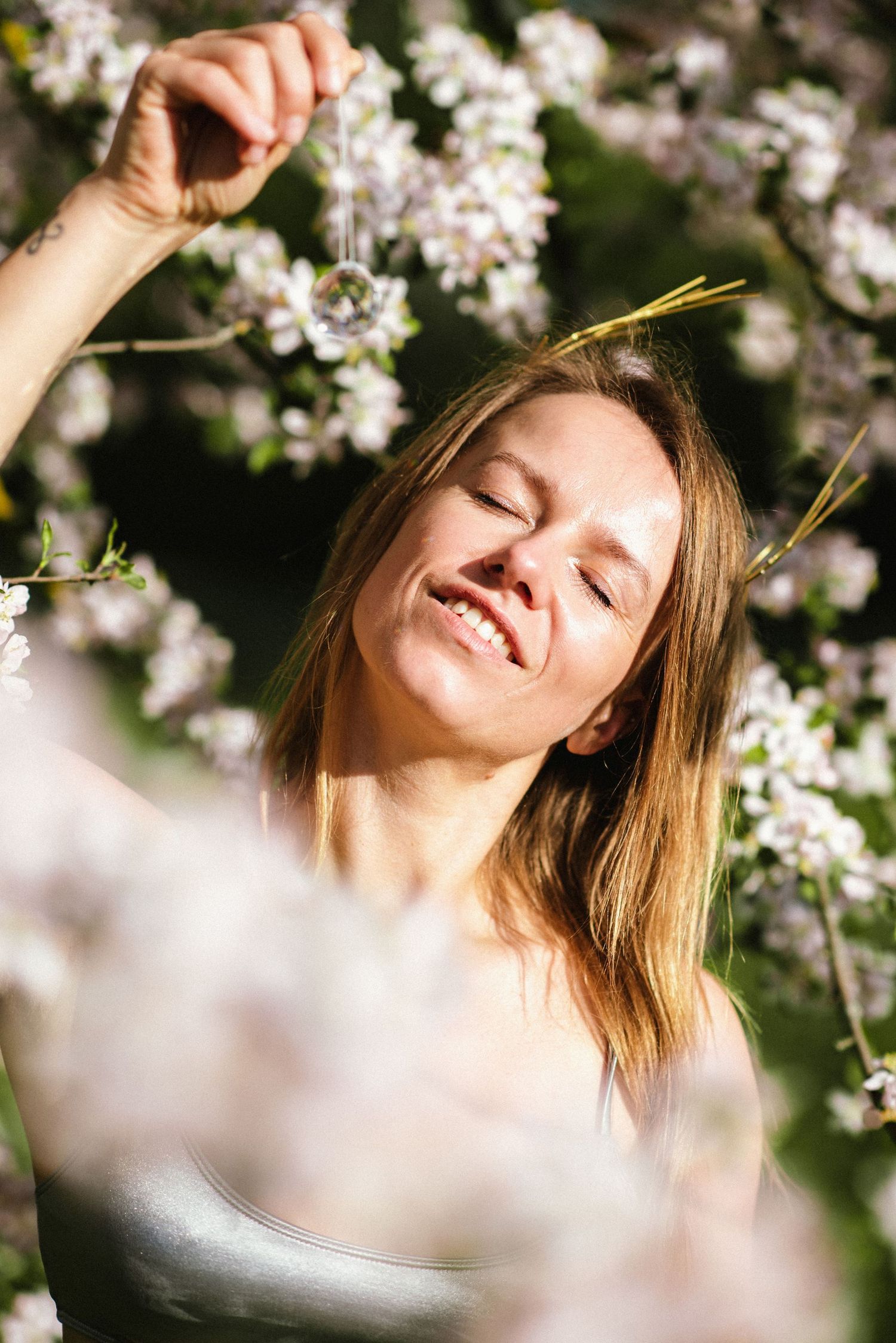 Delicate white cherry blossoms frame a sunlit spring portrait.
