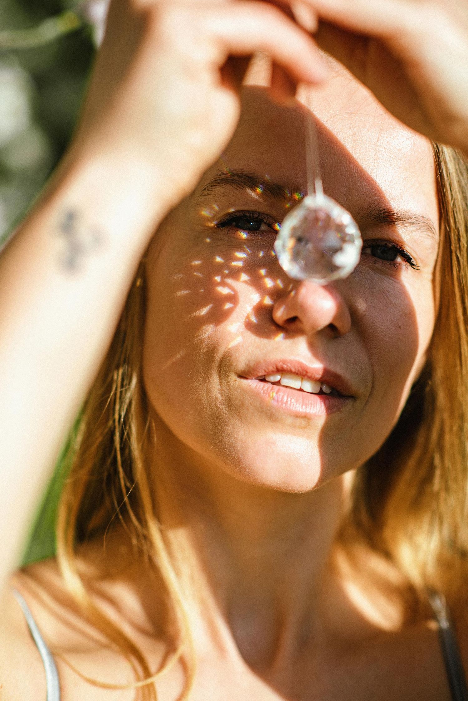 Dappled sunlight creates patterns across skin in warm natural lighting.