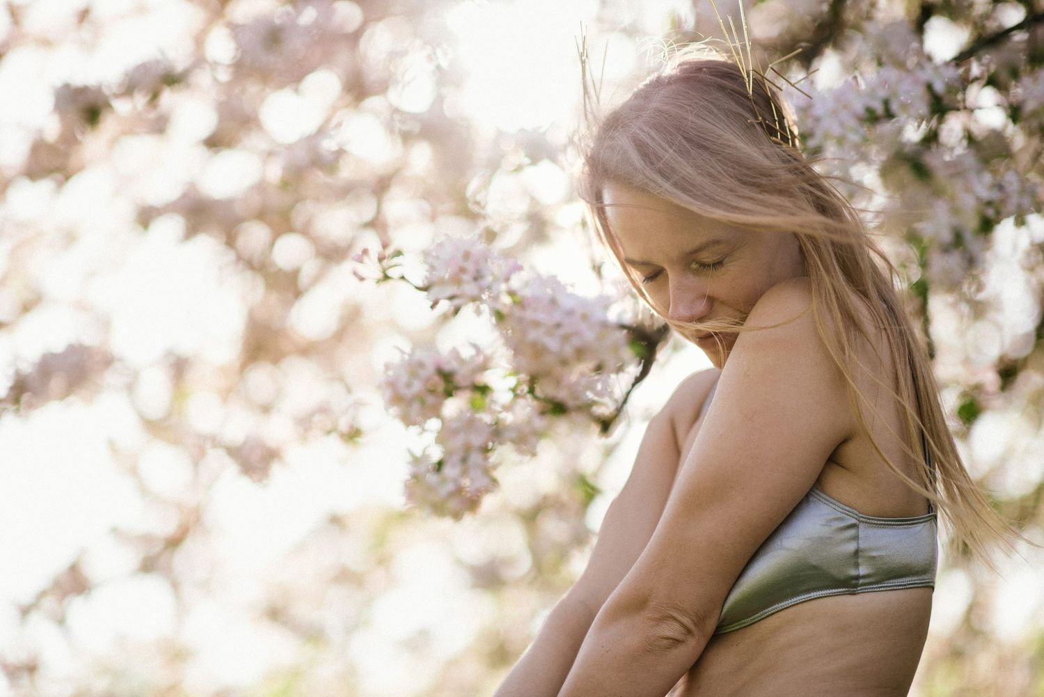 Ethereal springtime portrait with soft bokeh effect and delicate cherry blossoms.