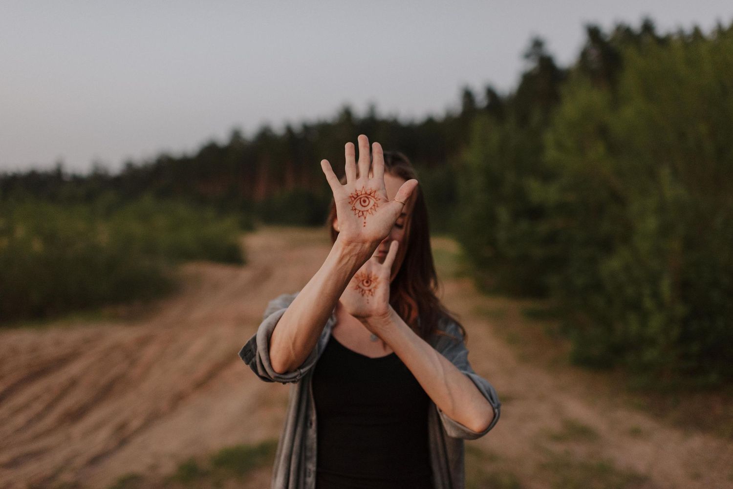 Silhouette of a person making gestures against a forest backdrop.