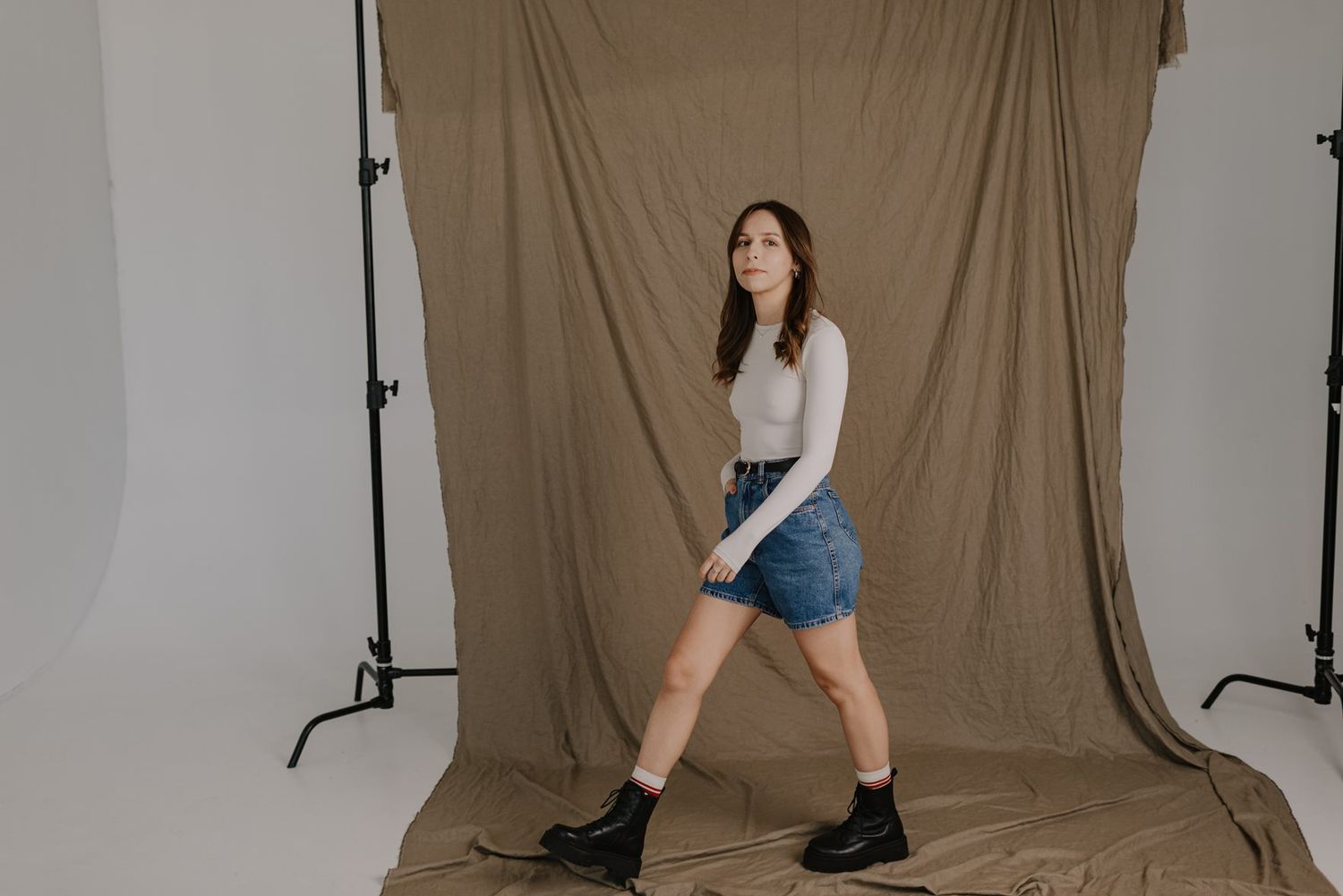 Studio portrait session featuring casual styling against simple backdrop.