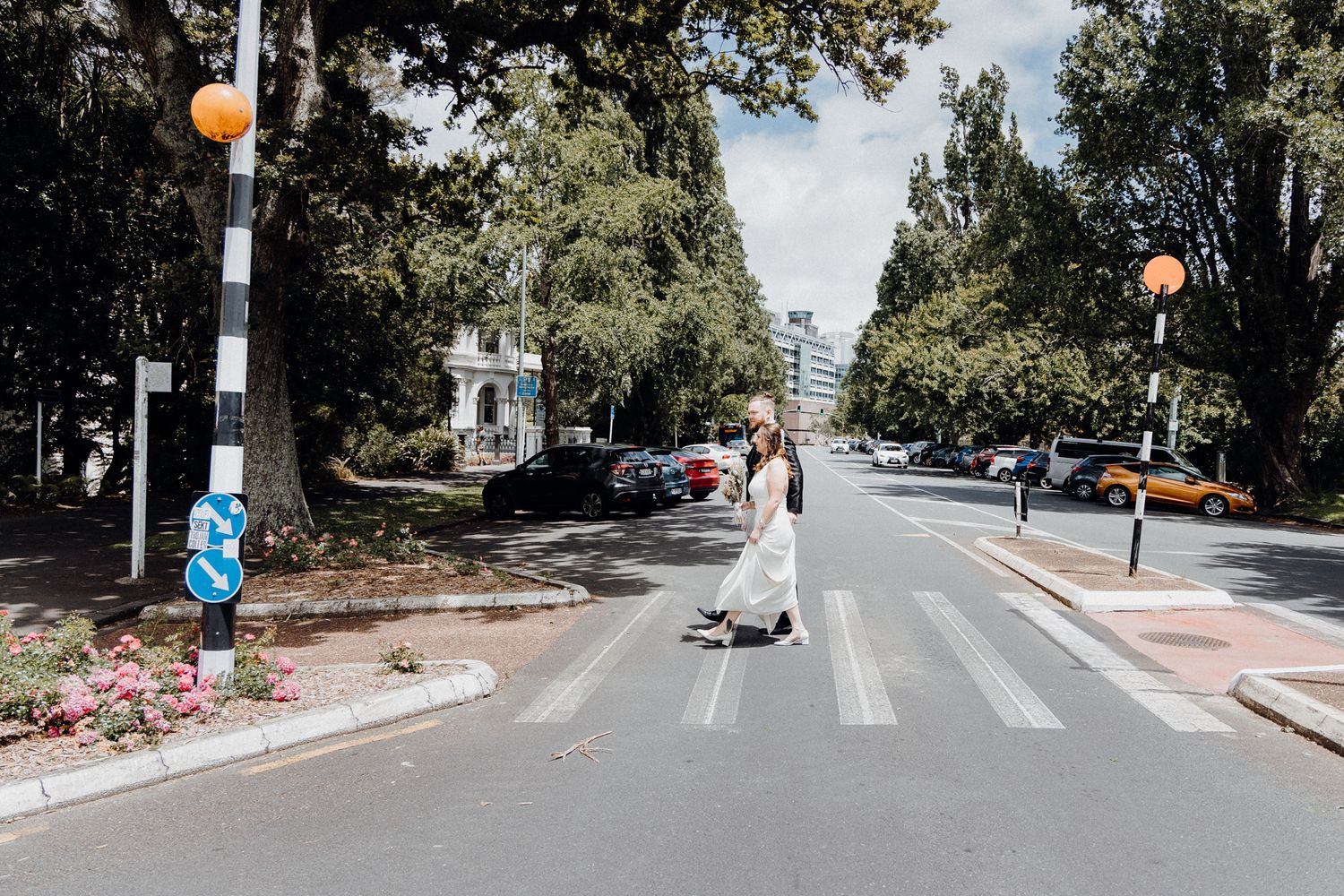 Newly Wed Couple crossing the street, captured by Apertured Media Auckland Wedding Photographer.