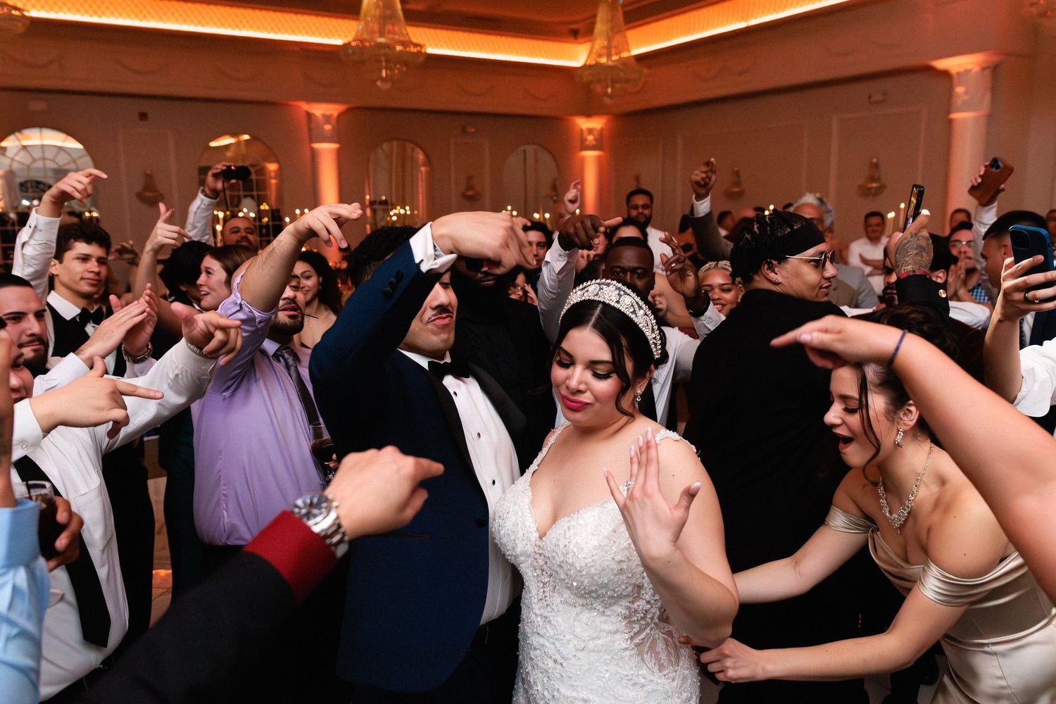 Bride and groom embracing tenderly outside a grand building on their wedding day.