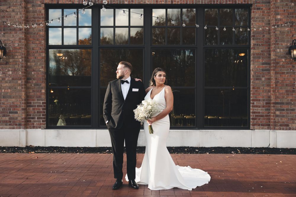 A timeless wedding moment in front of brick and glass—modern elegance meets classic romance in every frame at The Everly in Mentor, Ohio.