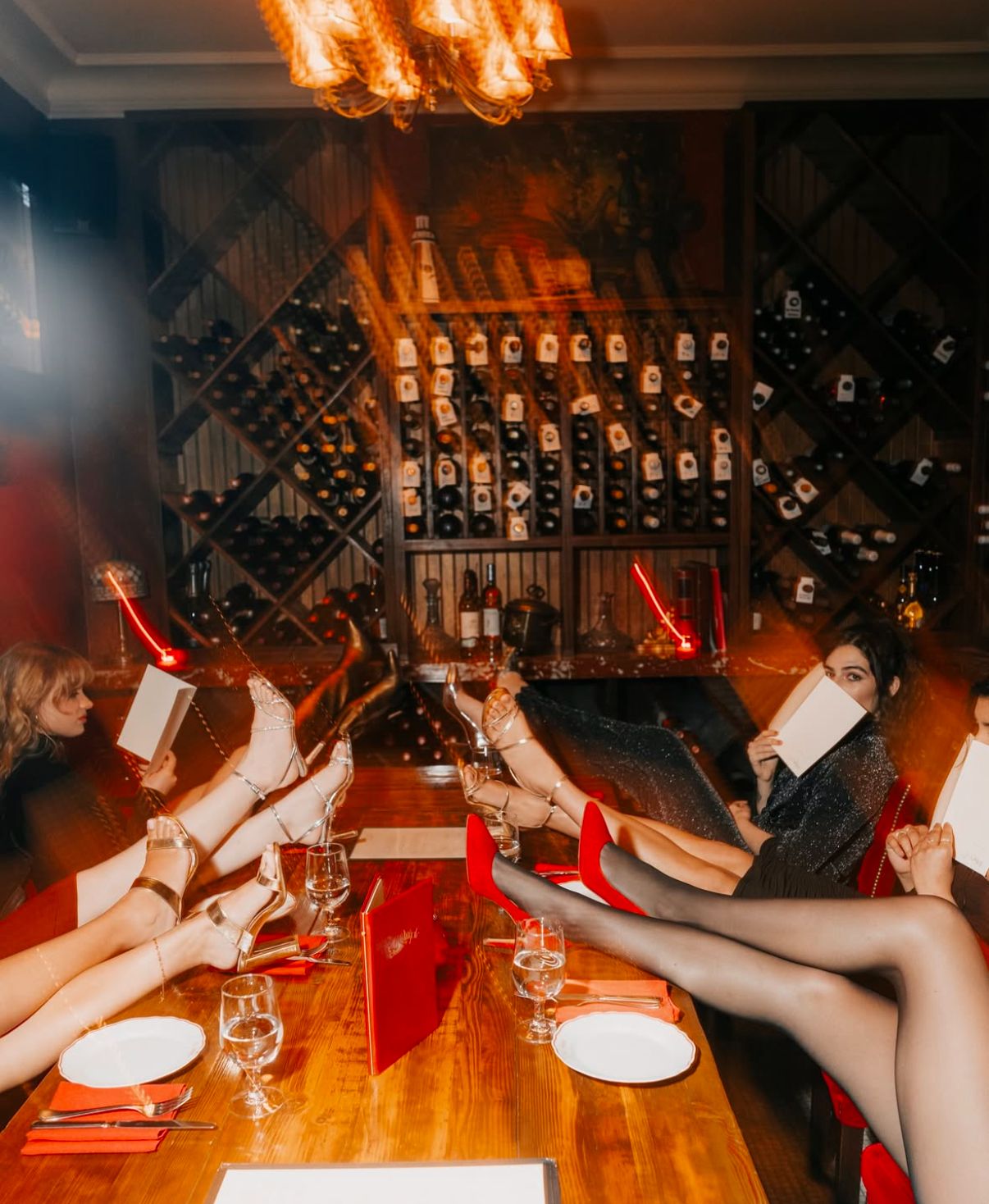 Group dining at wine cellar with feet up on table.