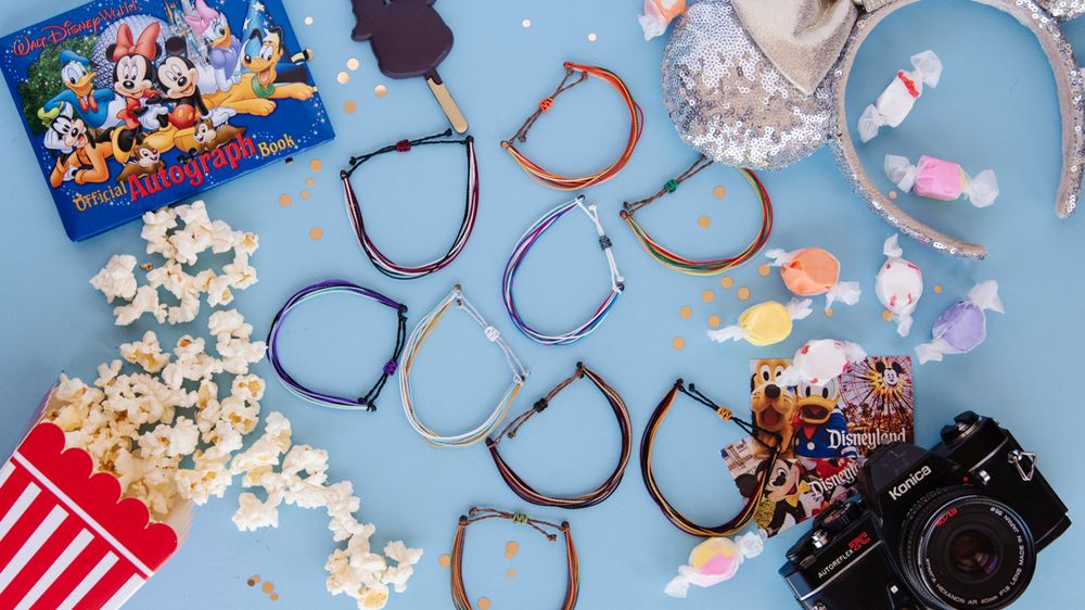 Disney themed accessories and headbands scattered among popcorn and camera.