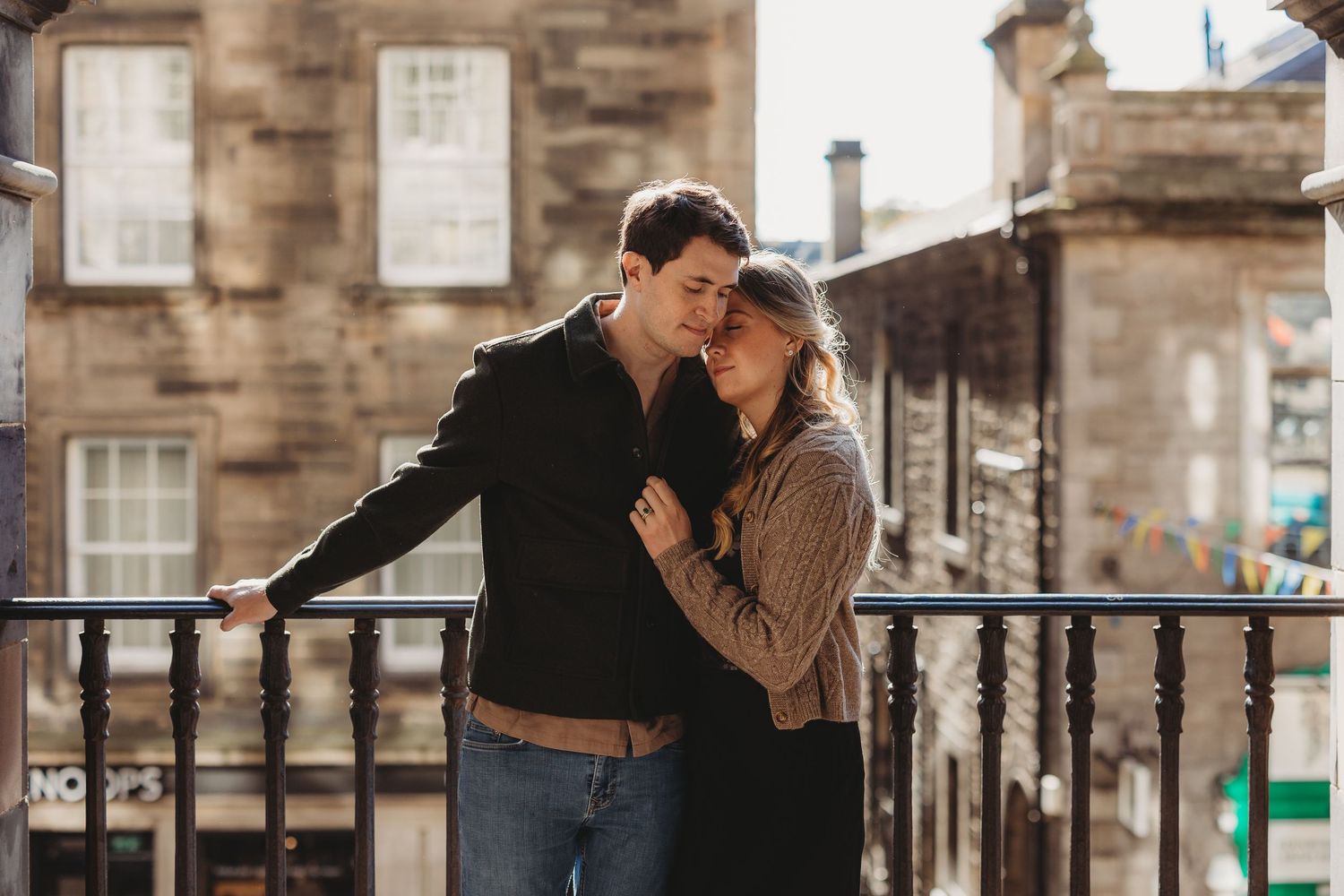 couple standing on the cobbled road holding hands in Edinburgh