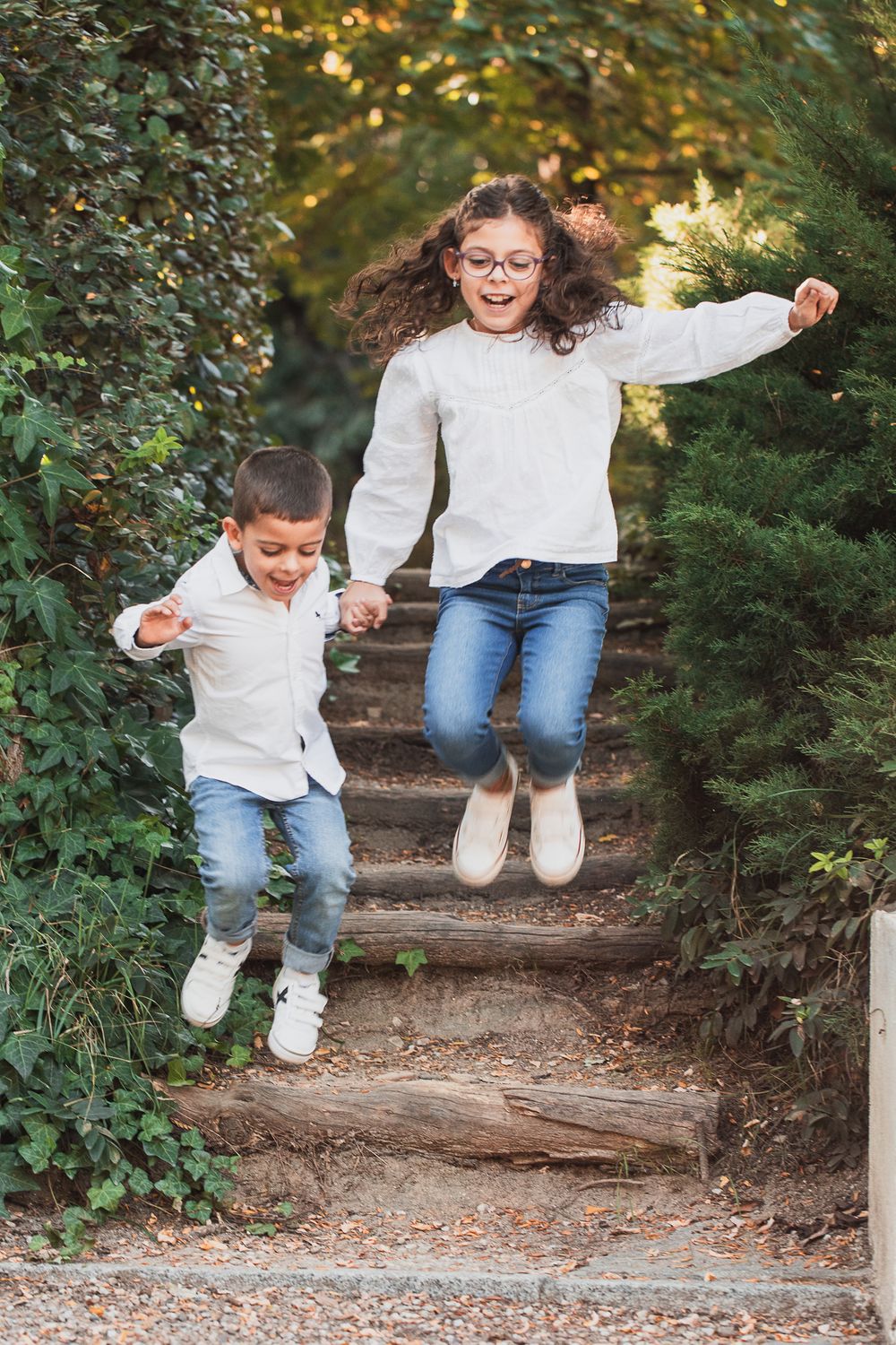 Playful jumping sequence on wooden steps surrounded by autumn foliage.