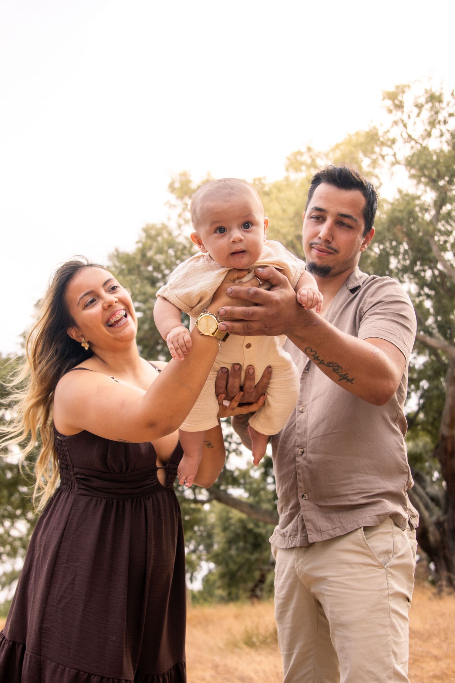 Joyful family photoshoot in a natural outdoor setting during sunset.