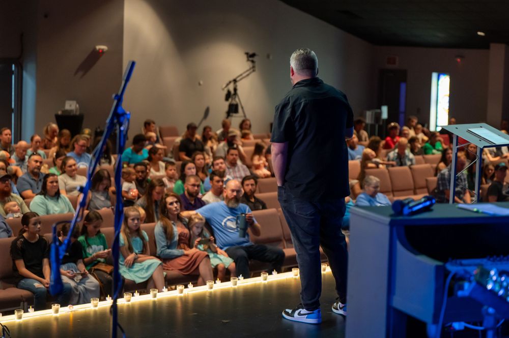 A crowded auditorium full of engaged audience members during a performance.