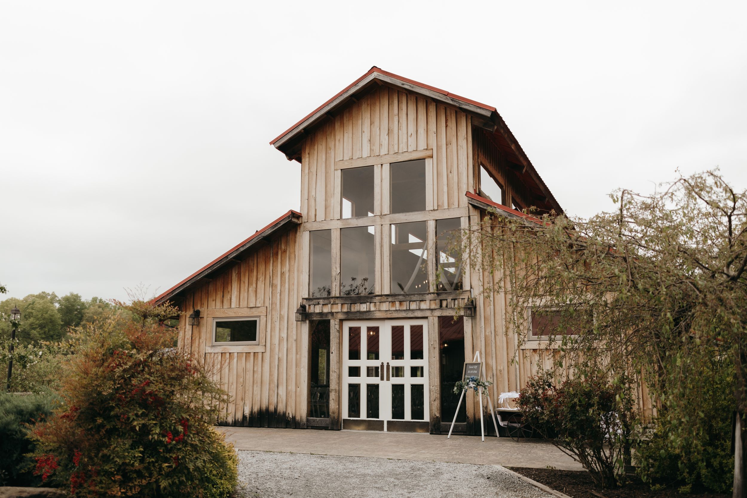 Rustic wooden barn wedding venue with large glass windows and cross detail.