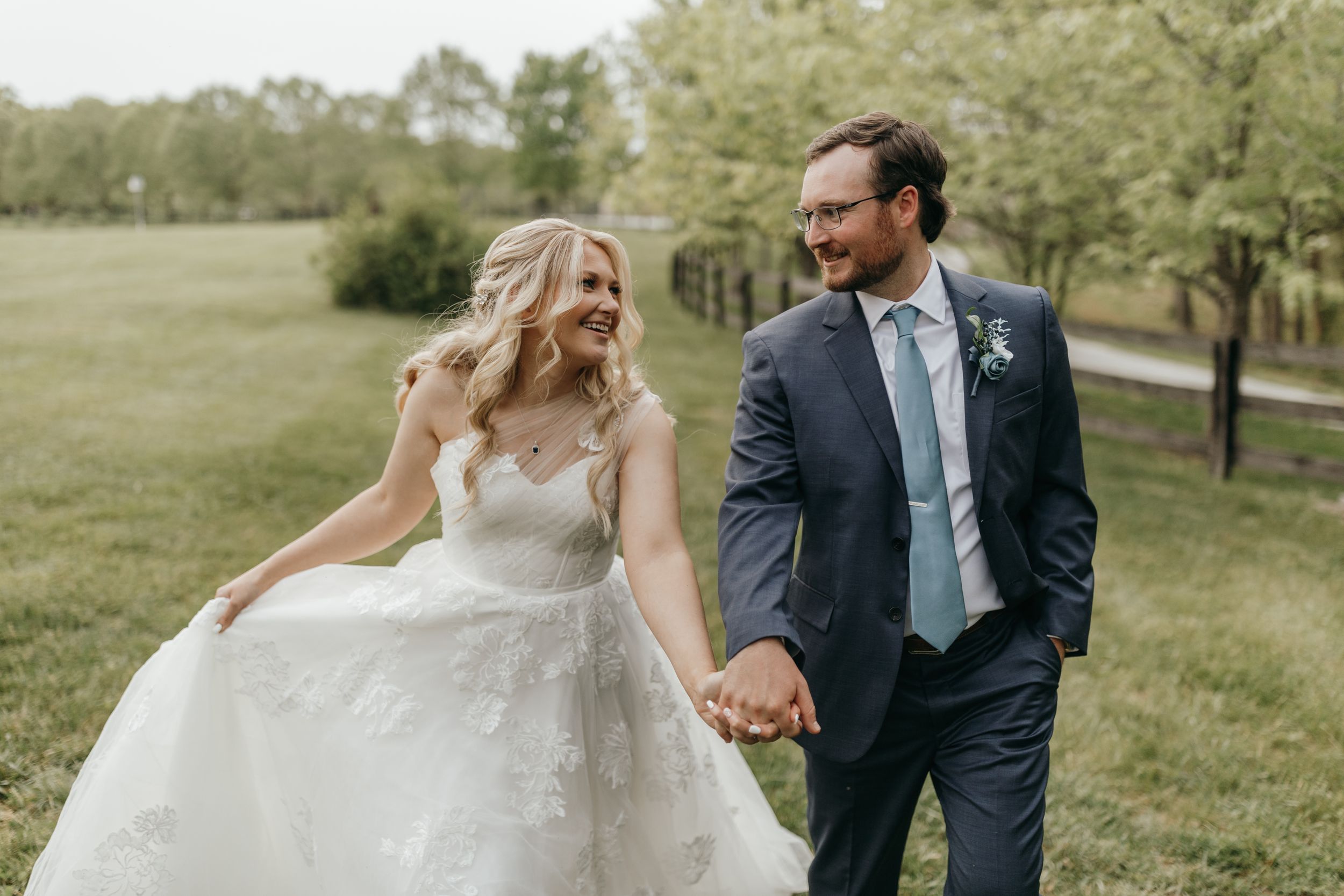 Joyful couple walking hand in hand outdoors on their wedding day.