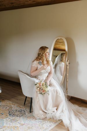 A bride in a flowing white wedding gown sits gracefully on a patterned rug in a series of artistic boudoir poses.