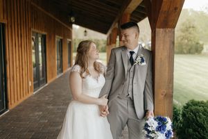 A couple shares a romantic moment on a rustic covered porch decorated for a wedding celebration.